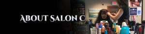 A woman standing in front of a sign with salon logos.