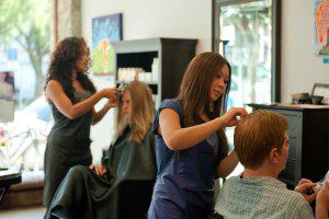 A woman is getting her hair cut at the salon